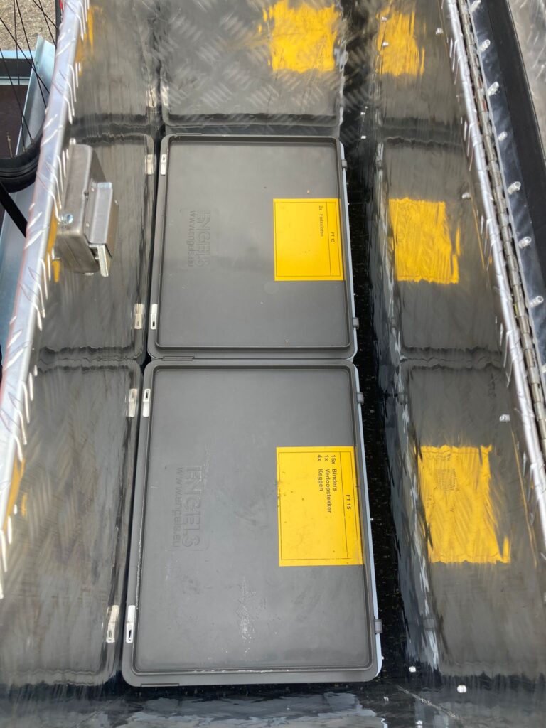 Opberg box in de disselkist met stikkers die vermelden wat er in de box moet zitten